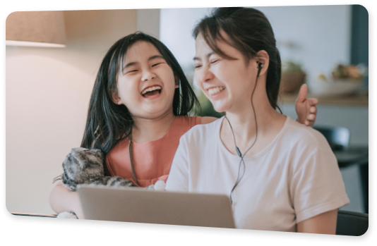 A mother wearing earphones, sharing laughter with her daughter